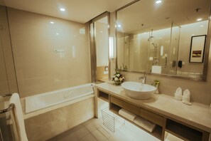 A modern bathroom with a bathtub, a large mirror, and a sink. - Holiday Inn Xi'an Big Goose Pagoda by IHG (Xi'an)