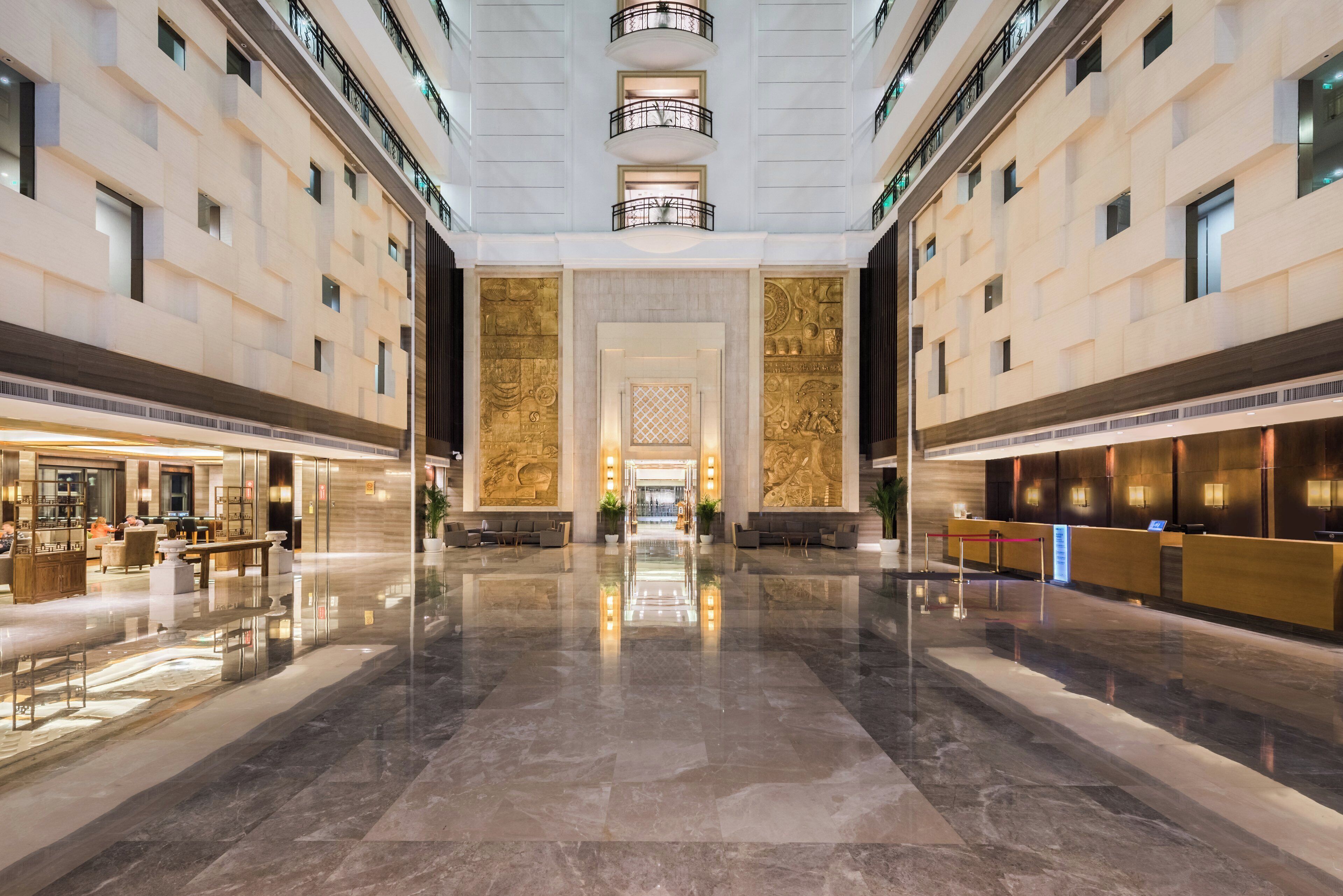 A spacious lobby with a marble floor, a reception desk, and a seating area.
