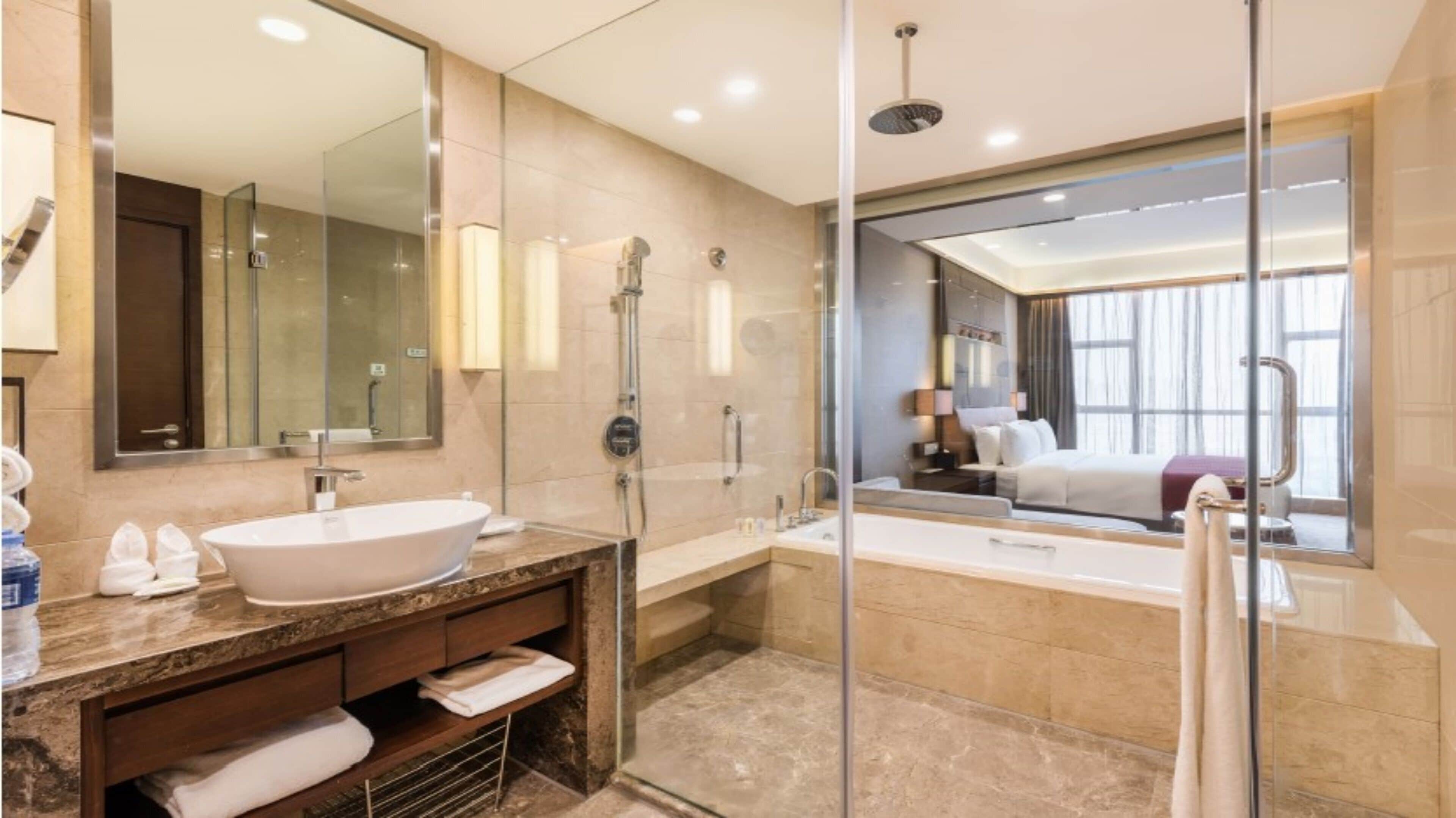 A modern bathroom with a freestanding bathtub, a large mirror, and a glass-enclosed shower area.