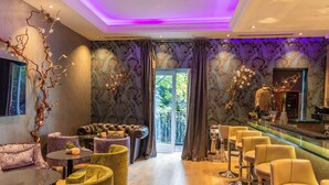 Un espace lounge moderne avec un bar, un canapé en cuir et des tabourets de bar.