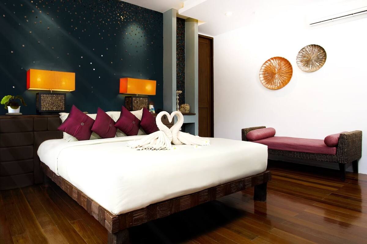 Une chambre moderne avec un grand lit, un canapé et un mur décoré de différents objets.
