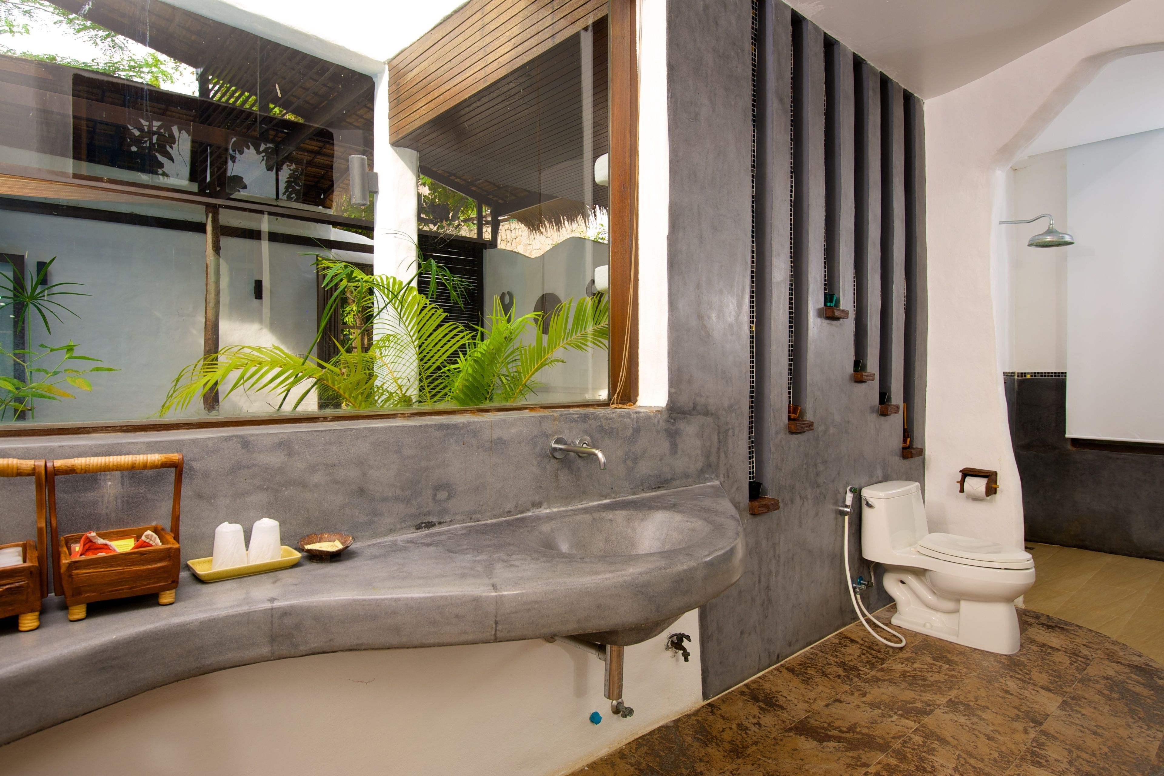 A modern bathroom with a large sink, toilet, and shower.