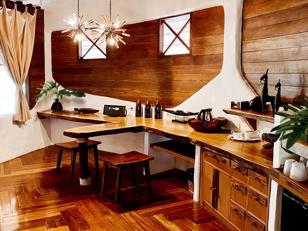 A kitchen with wooden cabinetry, a wooden countertop, and a hanging light fixture.