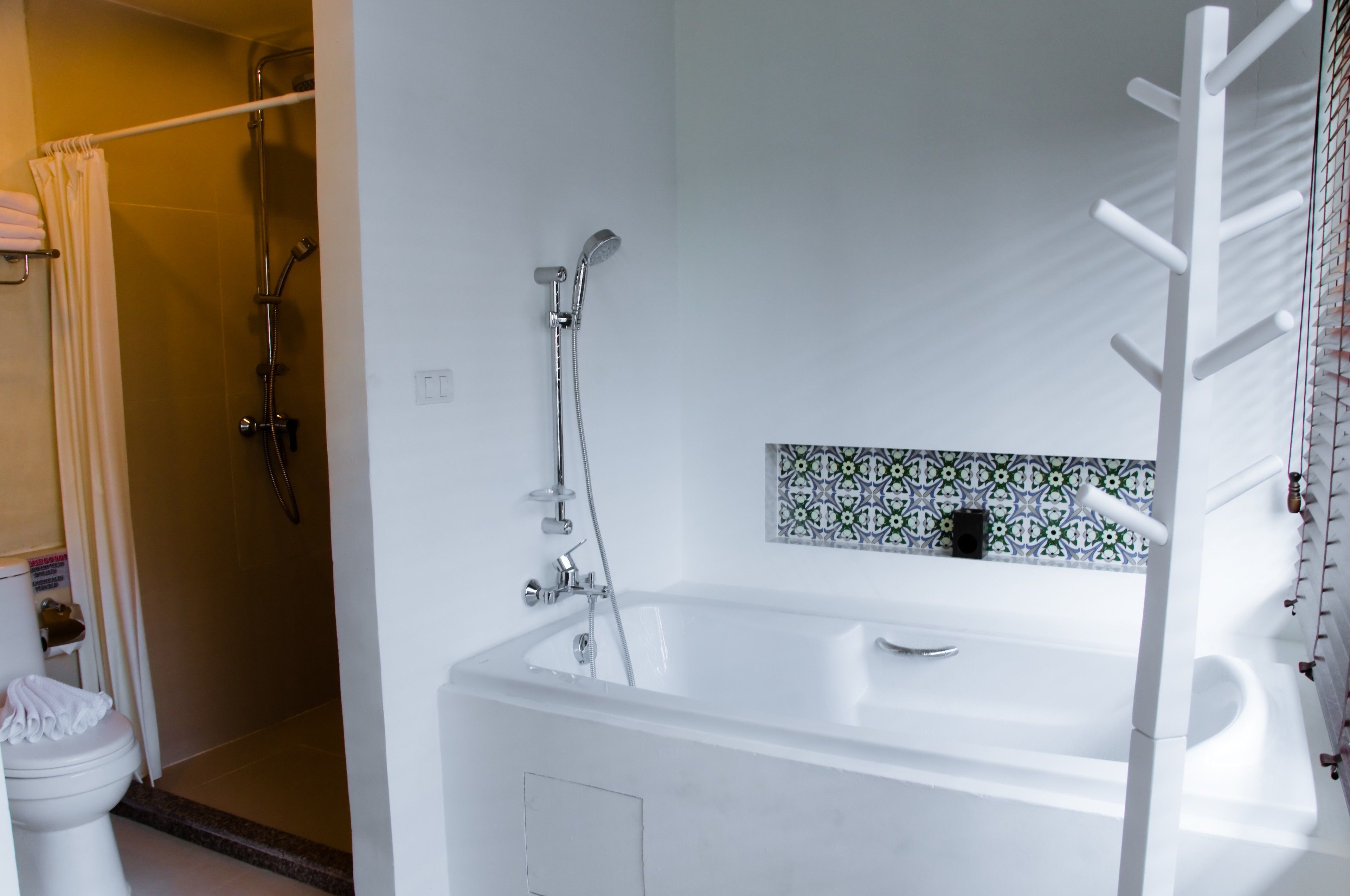 A modern bathroom with a bathtub, shower, and toilet.