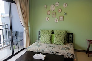 Una habitación con una cama, una mesa y un ventanal con cortinas.