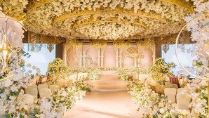 An indoor venue with a floral archway, seating arrangements, and a stage with a backdrop. - Pullman Linyi Lushang (Linyi)
