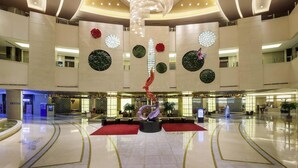 A spacious lobby with a central red carpet, a large chandelier, and decorative wall art. - Pullman Linyi Lushang (Linyi)