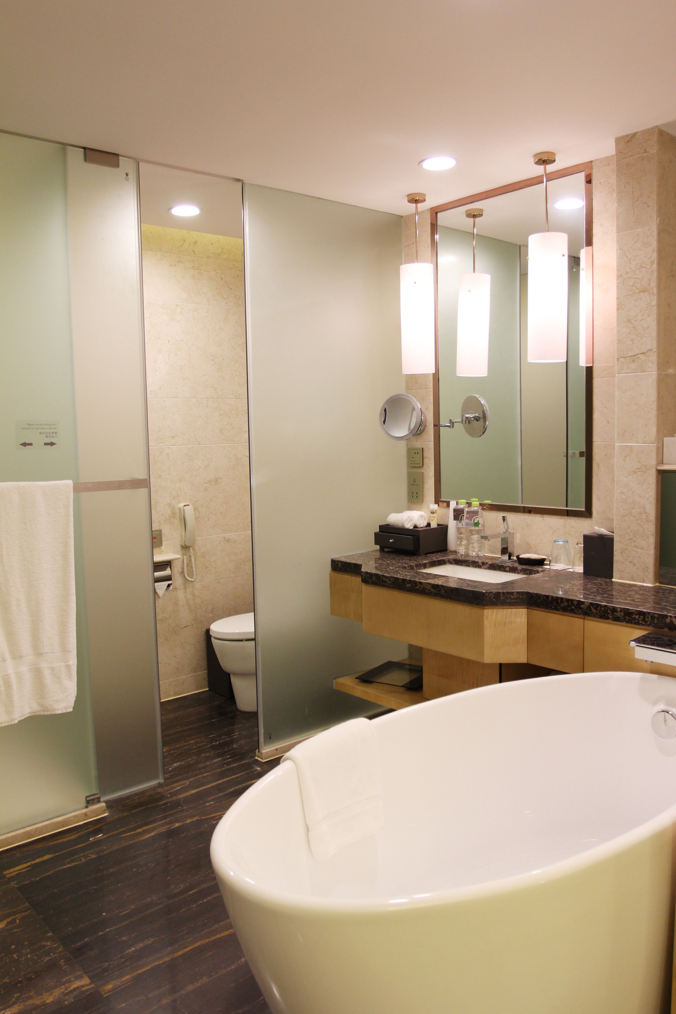A modern bathroom with a freestanding bathtub, a glass-enclosed shower, and a vanity with a mirror.