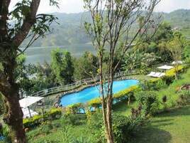 Una piscina al aire libre, sombrillas, sillones reclinables de piscina