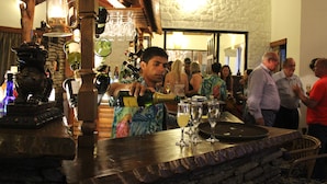 Un coin bar où un homme sert une boisson, entouré de clients.