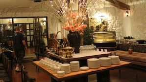 Un buffet avec plusieurs points de service, un grand arrangement floral central et une variété de plats et d’ustensiles.