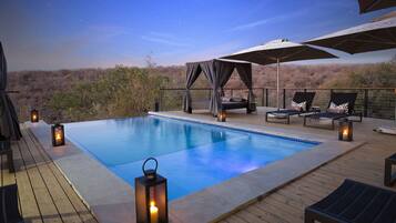 Una piscina al aire libre, sombrillas