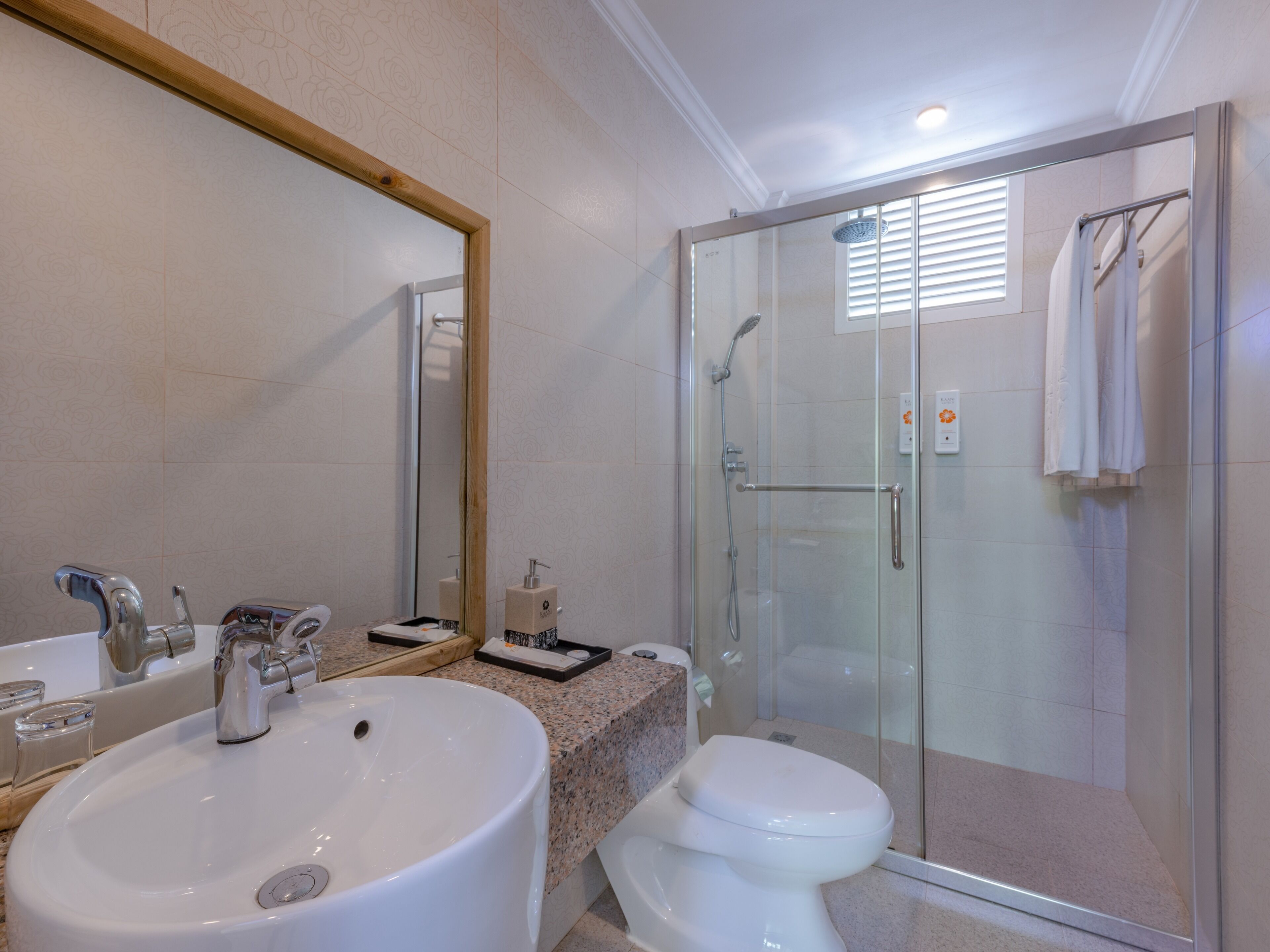 A bathroom with a sink, toilet, and glass-enclosed shower.