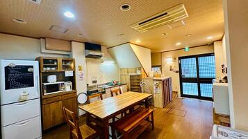 A small, cozy kitchen with wooden furniture, a refrigerator, microwave, and a sink.