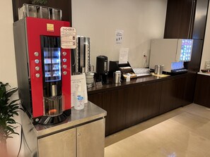 A coffee station with a red machine, a digital menu, and a social distance sign. - X-Wave Umeda（ORIX HOTELS & RESORTS） (Osaka)