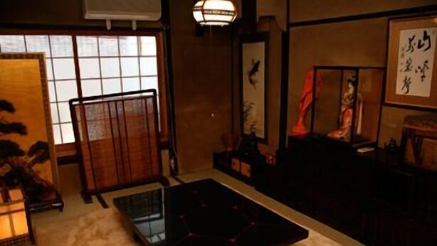 A traditional Japanese room with tatami flooring, a low table, and a sliding door. - Kaikoan (Kyoto)