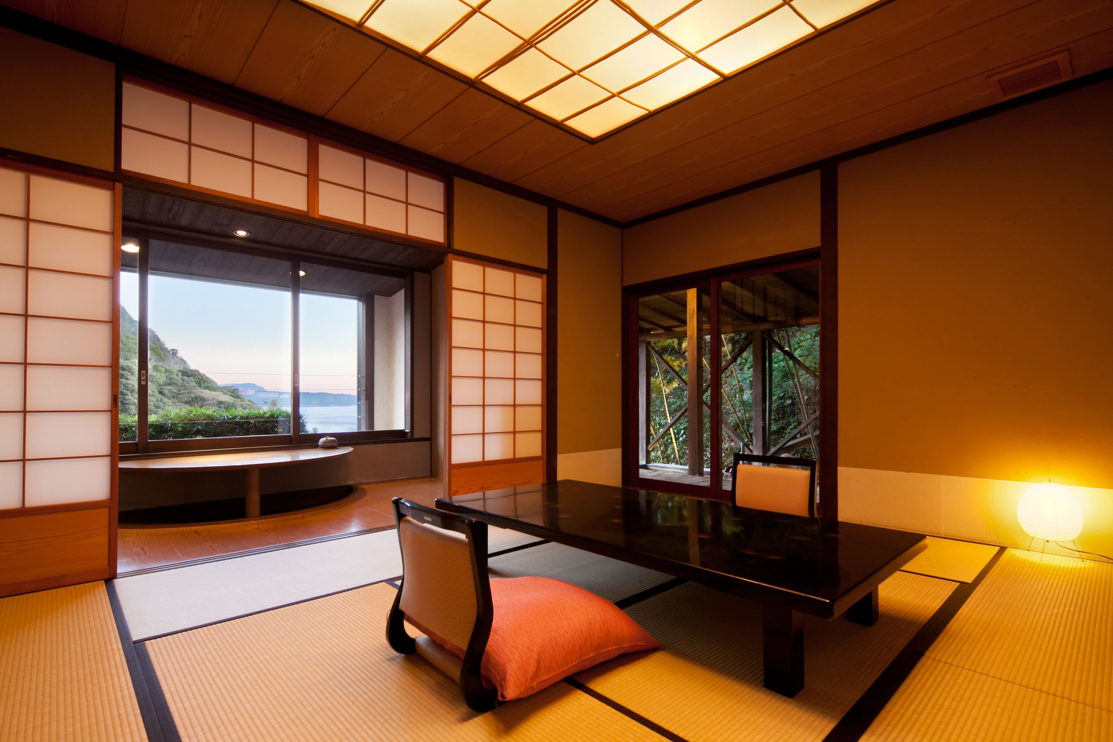 A traditional Japanese room with tatami flooring, a low table, and sliding doors.