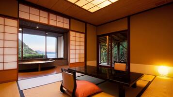 Um quarto japonês tradicional com tatames, uma mesa baixa e portas deslizantes.