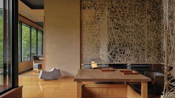 A modern interior with a wooden table, seating, and a decorative wall.