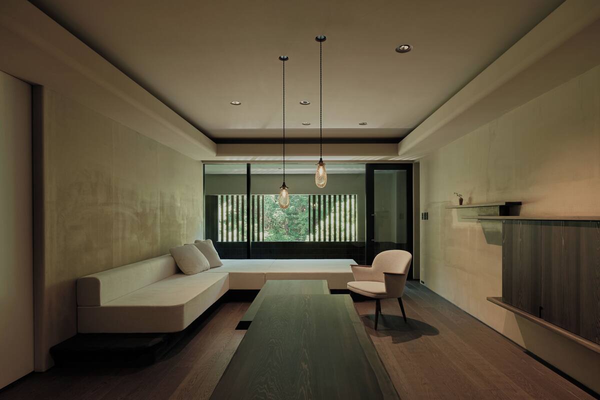 A modern living room with a built-in bench, a dining table, and a chair.