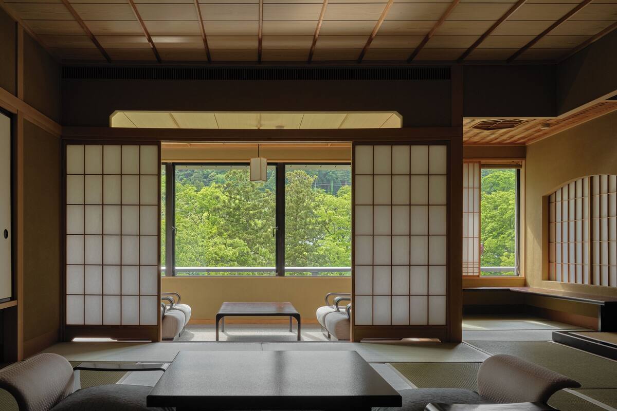 A traditional Japanese-style room with tatami flooring, a low table, and sliding doors.