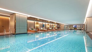 A large indoor swimming pool with lounge chairs and a modern design. - Crowne Plaza Huaihua by IHG (Huaihua)