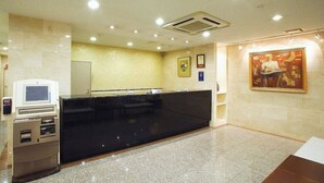 A reception area with a black reception desk, a self-service kiosk, and a painting on the wall. - Hamamatsu Hotel (Hamamatsu)