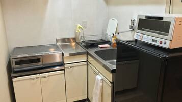 A compact kitchen with a built-in oven, a microwave, and a sink.
