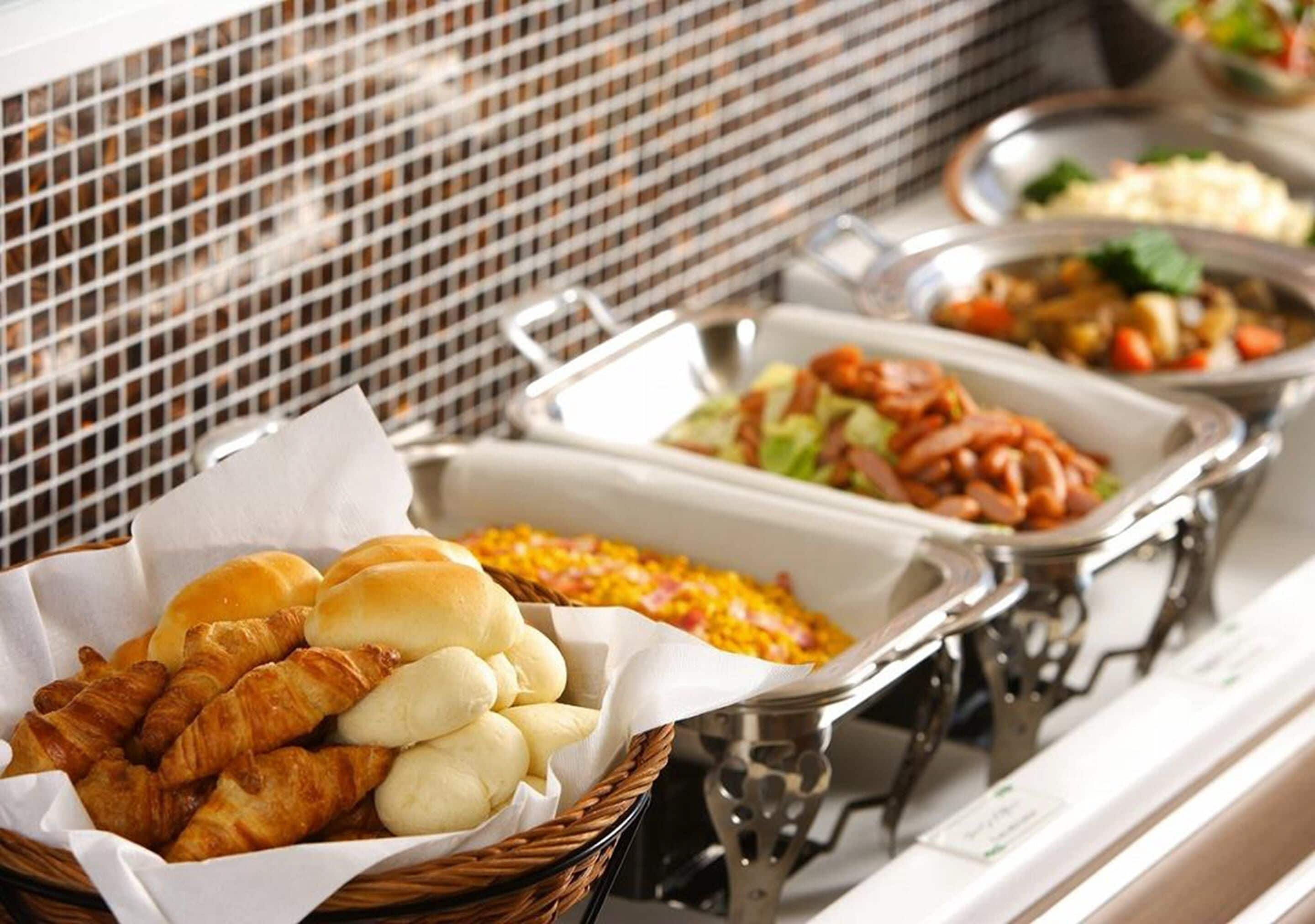 Ein Buffet mit verschiedenen Speisen, darunter Brot, Salate und Aufläufe.