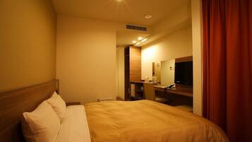 A hotel room with a bed, a desk, a chair, a television, and a mirror.