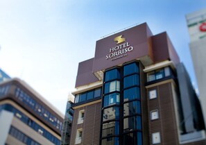 Hotel Sorriso, een hotel met een modern architectonisch ontwerp, herkenbaar aan een opvallend bord en reflecterende glasramen.