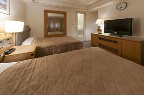 A hotel room with two beds, a TV, a desk with a phone, and a mirror. - Hotel Siena (Tokyo)