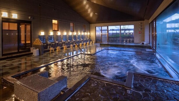 Un espace spa comprenant un bain à remous, un coin salon et une vue sur l’extérieur.