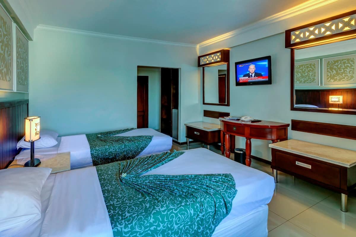 Une chambre d’hôtel avec deux lits, un bureau, une chaise, une télévision et un miroir.