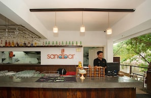 A bar area with a counter, glasses, bottles, and a sign reading "sandbar". - Maharani Beach Hotel (Kuta)