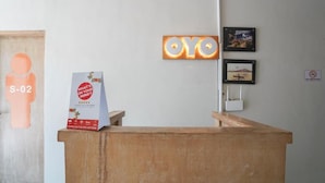 A reception desk with a sign for the OYO app, a 'What's on your mind?' feedback box, and a 'NO SMOKING' sign. - Cityzen Renon Hotel (Denpasar)