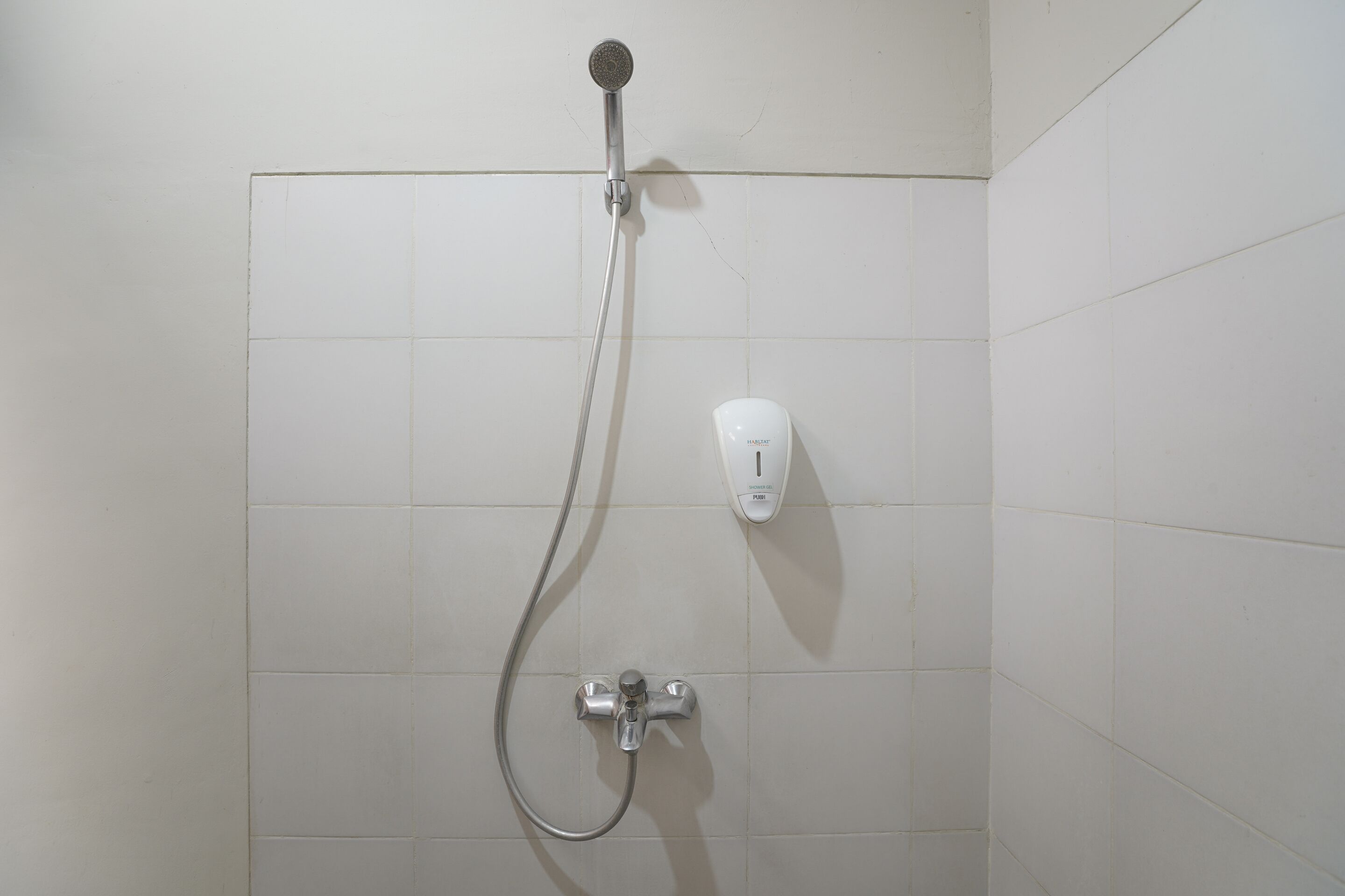 Una ducha con cabezal de ducha de mano y grifo empotrado.