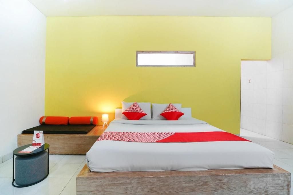 Quarto de hotel com cama, mesa de cabeceira e janela.