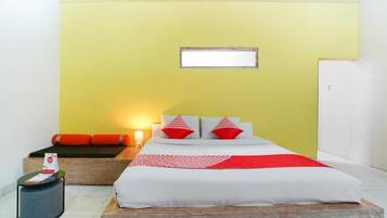 A hotel room with a bed, a bedside table, a nightstand, and a window.