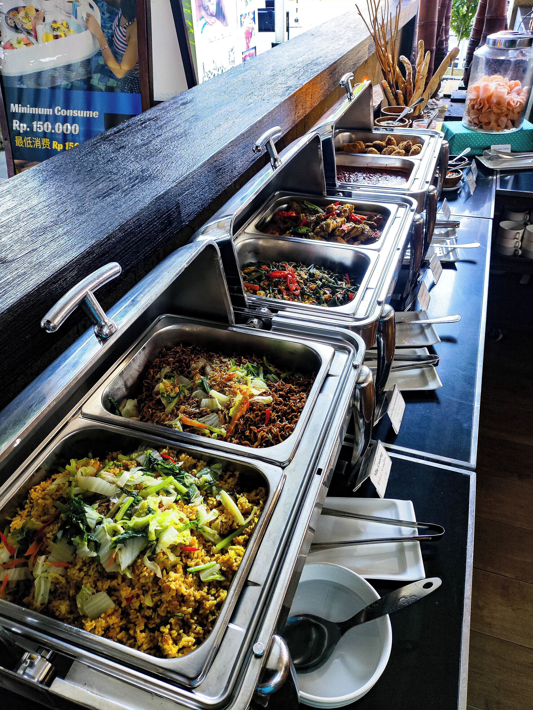 A buffet with multiple food stations, including rice dishes and stir-fries.