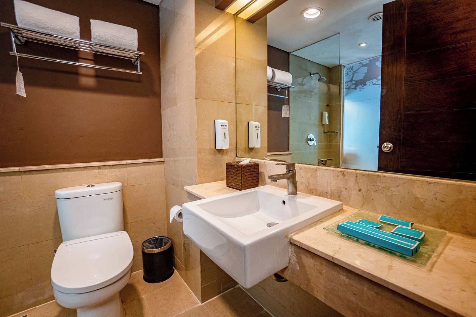 A modern bathroom with a toilet, sink, and mirror.