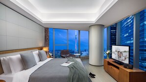 A modern hotel room with a large bed, a television, and a view of a cityscape. - Ascott IFC Guangzhou (Guangzhou)