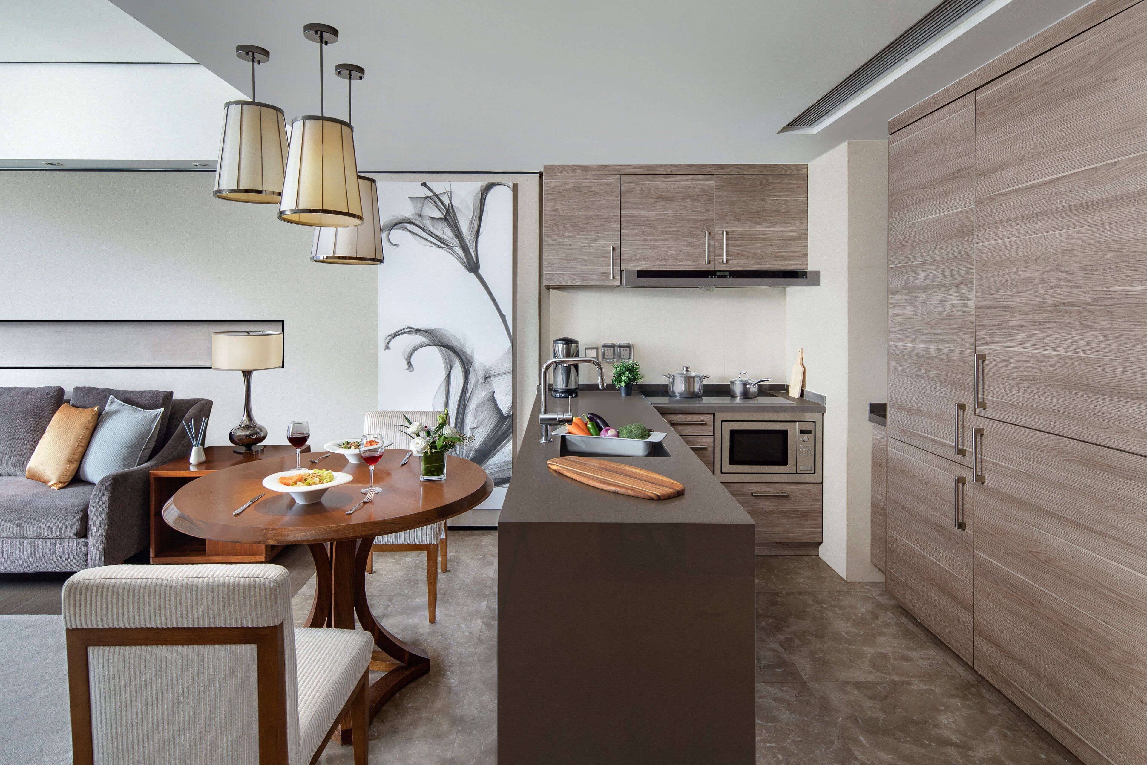 A modern kitchen with wooden cabinets, a central island, and pendant lighting.