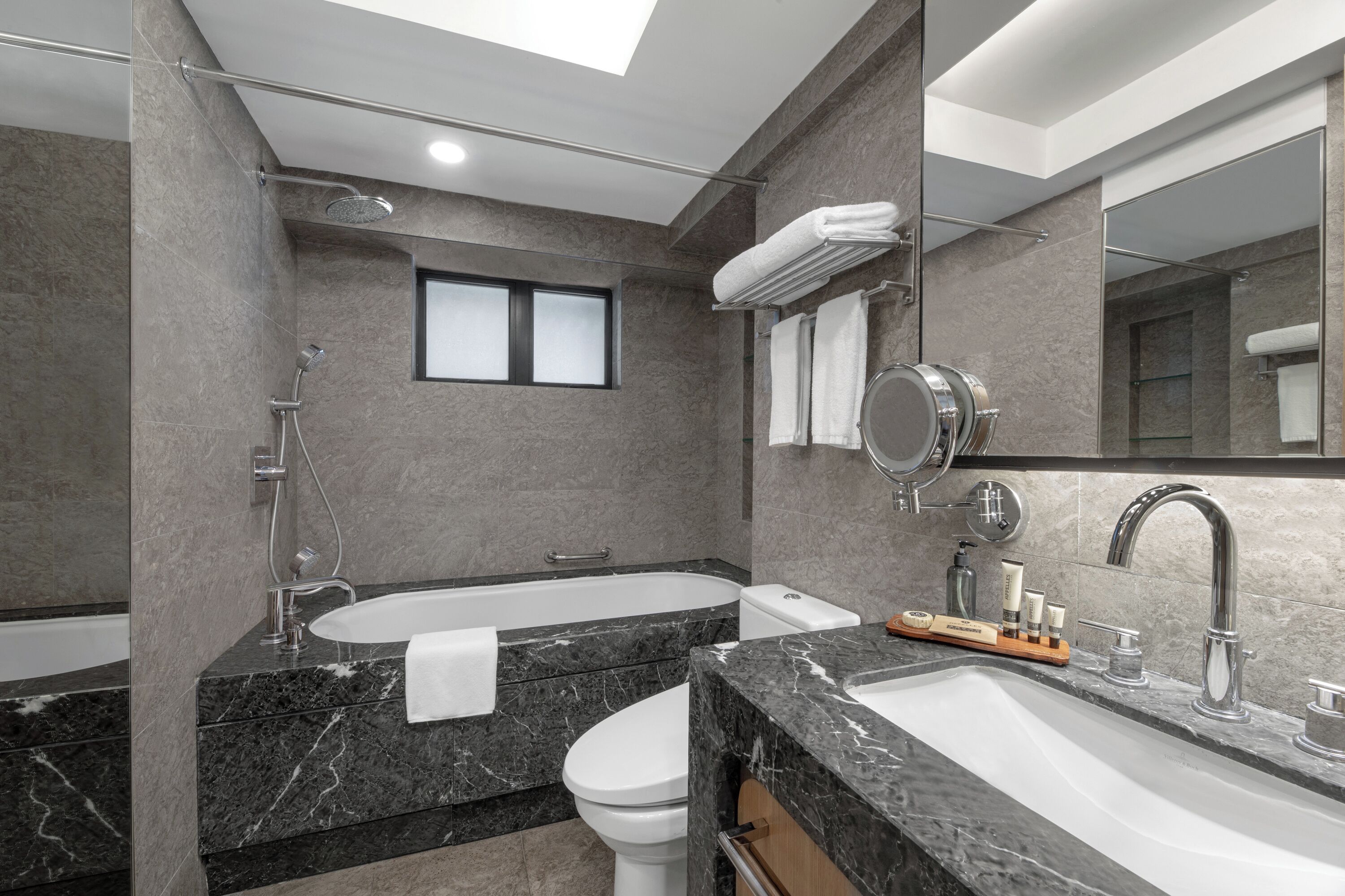 Un bagno moderno con vasca, doccia separata e un mobile lavabo.