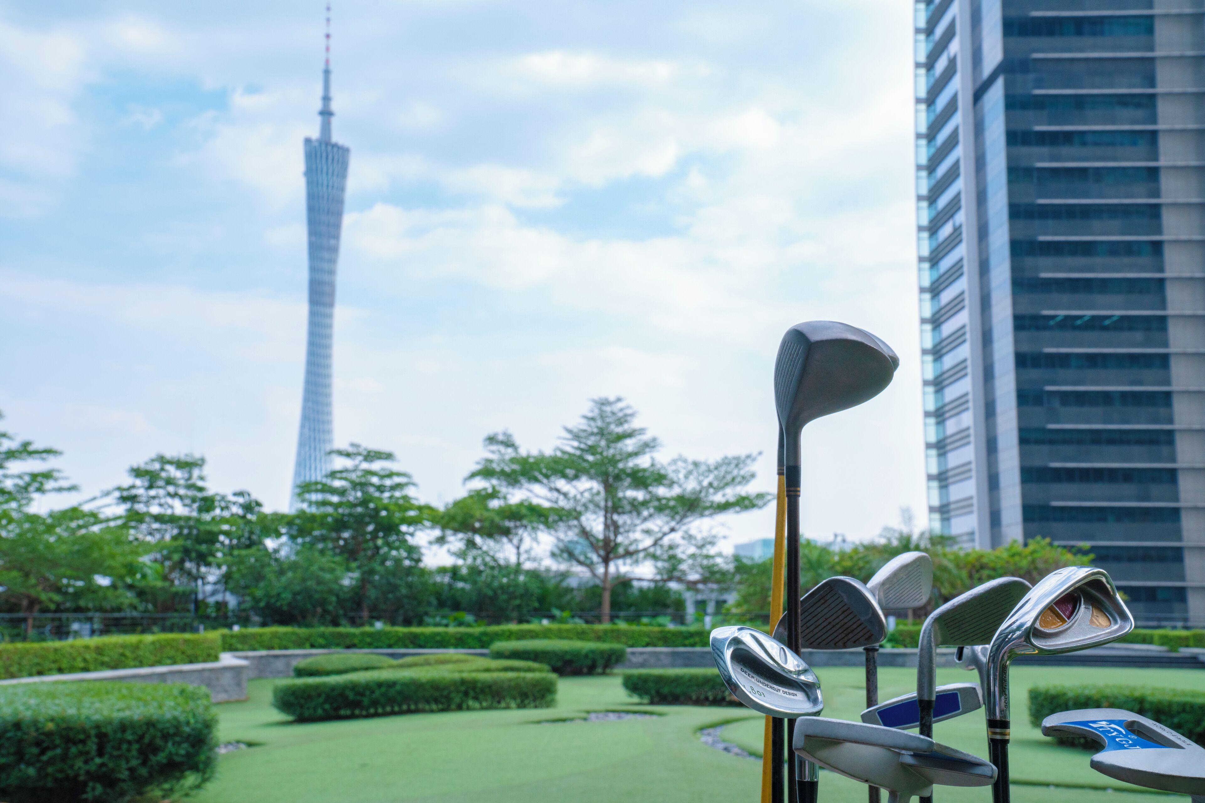 A golf club set in a park with a tall building in the background.