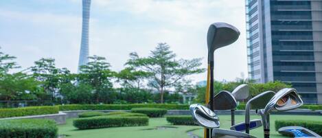 A golf club set in a park with a tall building in the background.