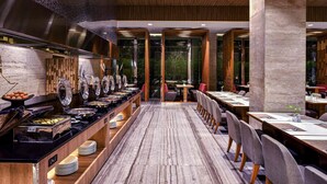 Un buffet proposant une variété de plats, une longue table en bois et un décor intérieur moderne.