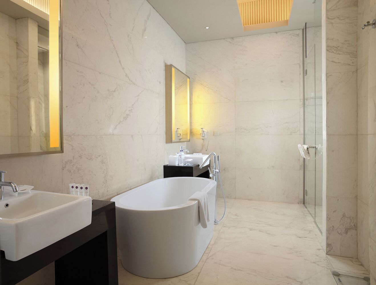 Une salle de bain moderne avec une baignoire sur pieds, un grand miroir et une douche à parois de verre.
