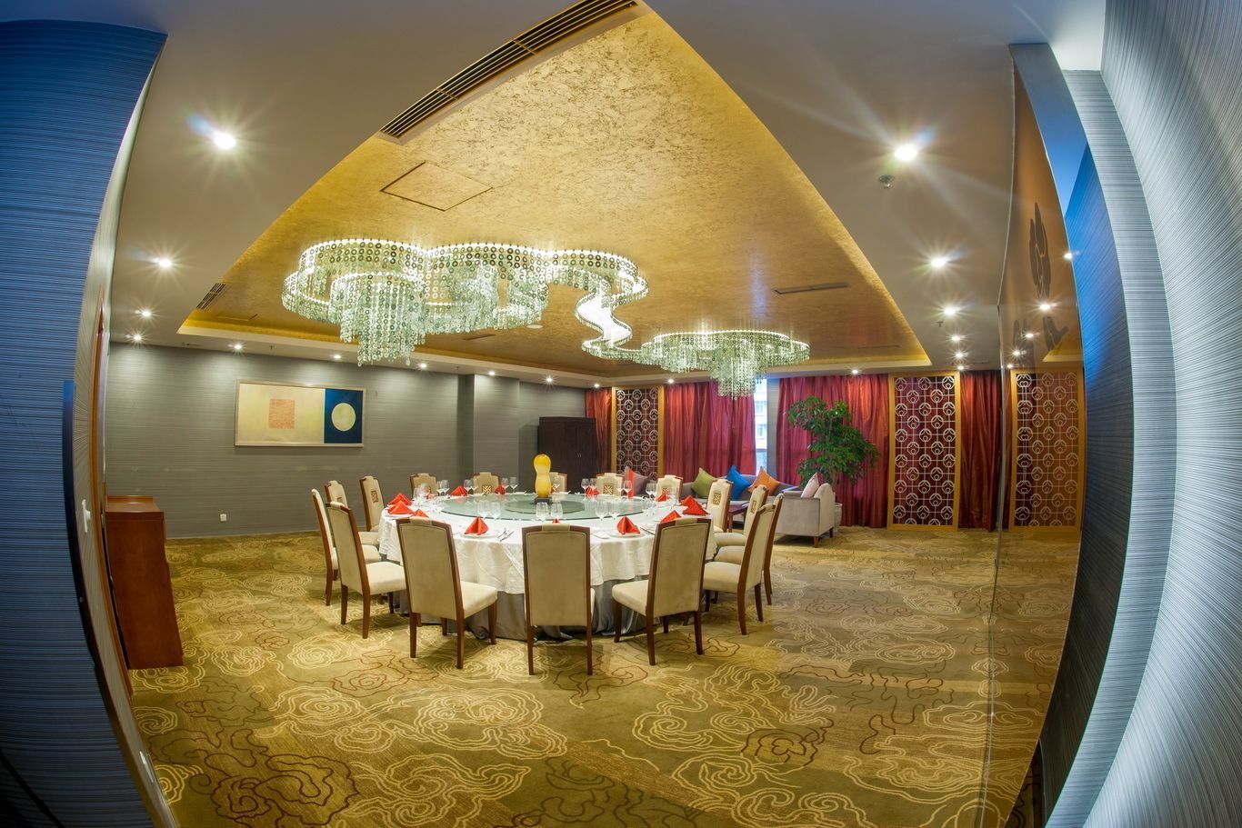 A conference room with a round table, chairs, and a chandelier.