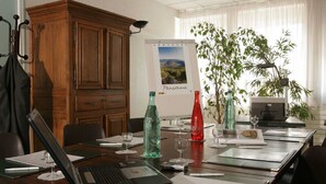 Una sala de conferencias con un armario de madera, un cartel y una mesa lista para una reunión.